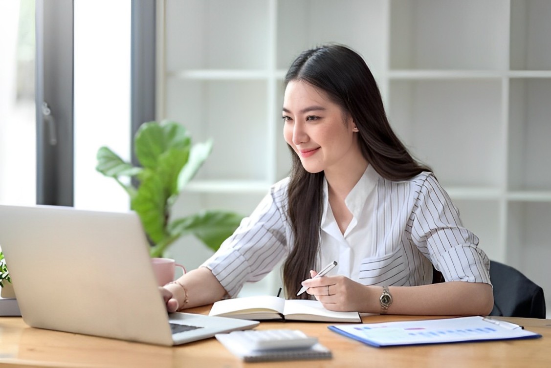 Free Photo Self-employed mid adult woman preparing schedule while looking at laptop on table in garden-2